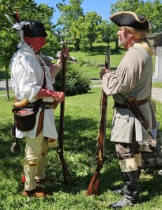 Dialogue between a man dressed as an early pioneer and a man dressed as a native American.